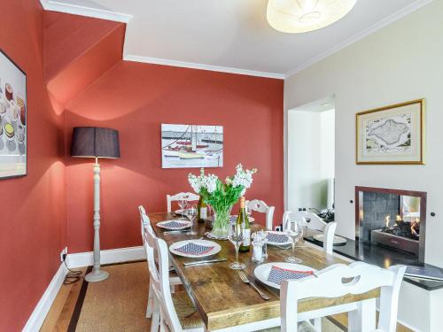 a dining room with red walls and a wooden table and chairs at Lapwing in Yarmouth