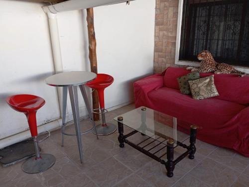 a living room with a red couch and red stools at Casa ciudad de la Costa in Ciudad de la Costa