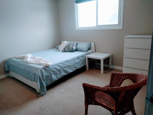 ein Schlafzimmer mit einem Bett und einem Stuhl und einem Fenster in der Unterkunft UofA Bike Lane-Train-Bus- Southgate Mall, Cental in Edmonton