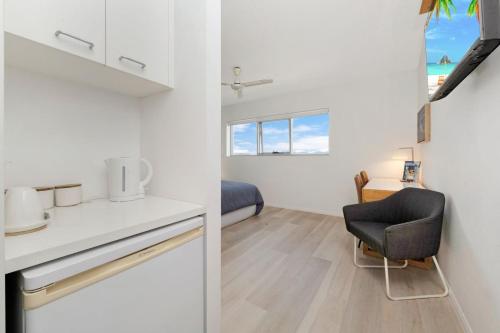 een keuken en een woonkamer met een tafel en een stoel bij Marina View Studio Apartment in Townsville