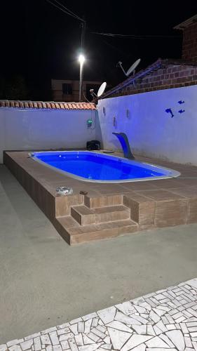 a jacuzzi tub with blue water and stairs at Casa de Carne de Vaca in Goiana