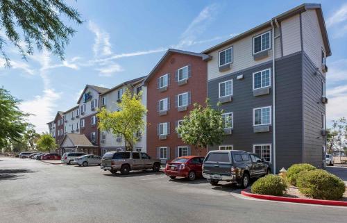 a row of buildings with cars parked in a parking lot at Extended Stay America Select Suites - Phoenix - West in Phoenix