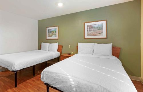 twee bedden in een kamer met groene muren bij Extended Stay America Select Suites - Phoenix - West in Phoenix