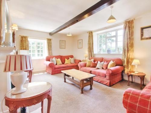 a living room with red couches and a table at Carriage House - E5119 in West Burton
