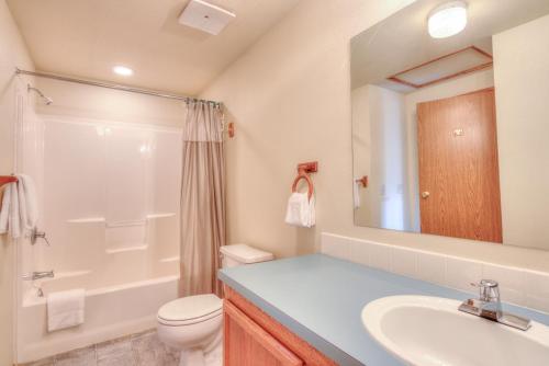 a bathroom with a sink and a toilet and a mirror at Starboard Cottage in Waldport