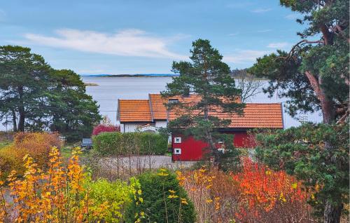 a red house with a lake in the background at Stunning Home In Tjøme With Private Swimming Pool, Can Be Inside Or Outside in Nord Måkerøy