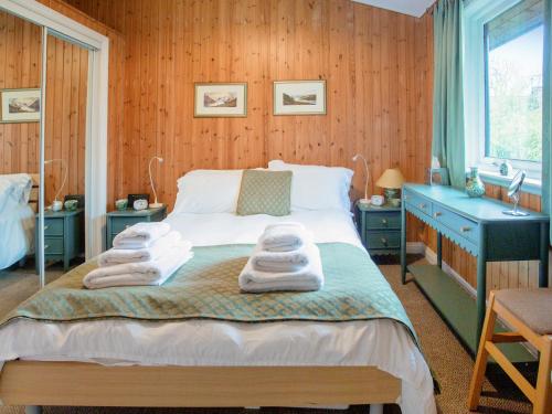 a bedroom with a bed with towels on it at Amber Nook in Tirril