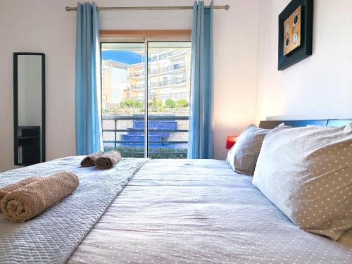 een slaapkamer met een groot bed met een raam bij Luxury Apartment Ocean View by Be Cherish in Albufeira