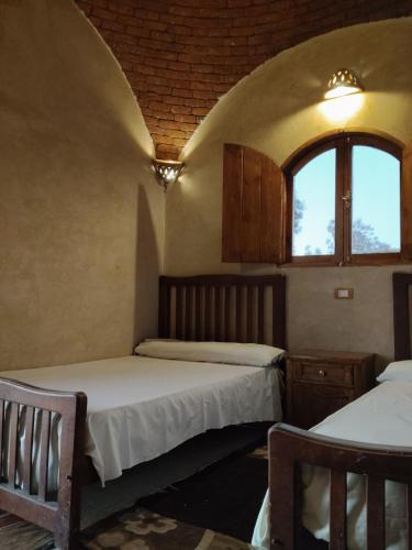 two beds in a room with a window at Friendo's House & Hot Spring in Siwa