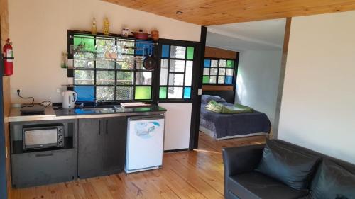 a kitchen with a sink and a microwave in a room at La casita del bosque en Muelle Delta Arias in Tigre