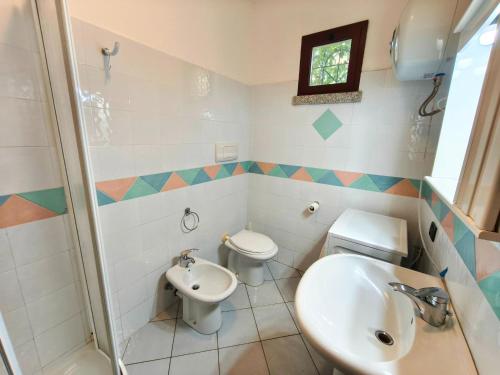 a bathroom with two toilets and a sink at Apartment with Pool and Private Parking in Porto Ottiolu