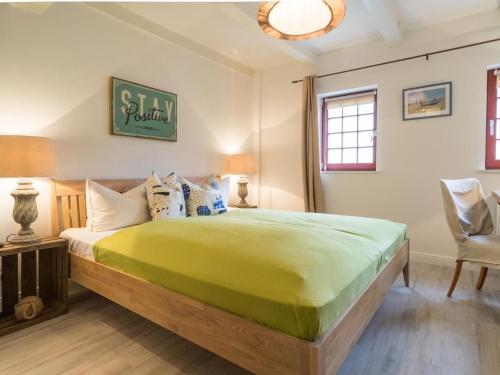 ein Schlafzimmer mit einem großen Bett und einem Stuhl in der Unterkunft Villa Bellevue3 - Apartment 12 in Ahlbeck