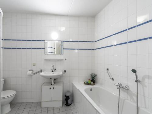 a bathroom with a sink and a toilet and a bath tub at Apartment in Zoutelande near beach in De Zandloper