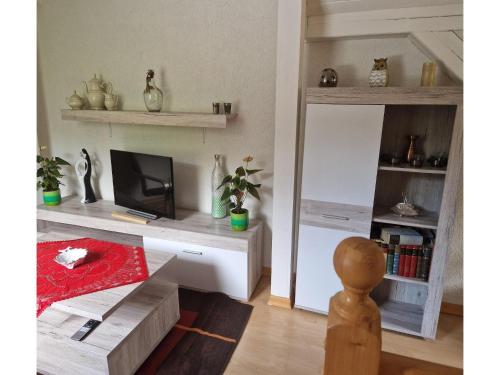 a living room with a desk with a tv at Gemütliches Ferienhaus mit Pool in Blankenburg in Blankenburg