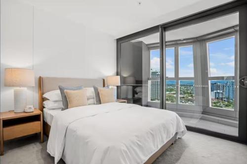 ein Schlafzimmer mit einem großen Bett und einem großen Fenster in der Unterkunft JEWEL RESIDENCE Luxury Surfers Paradise Apartment with Shared Pool in Gold Coast