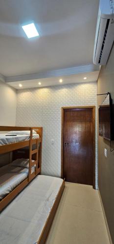 a room with two bunk beds and a door at Loft proximo a orla 01 in Presidente Epitácio