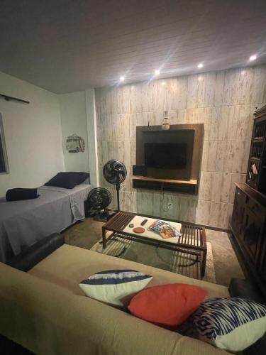 a living room with two beds and a tv at Apê da Lêda Loft - 400m da Praia do Forte in Cabo Frio