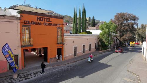 a person riding a motorcycle down a street next to a building at Hotel Colonial Guanajuato in Guanajuato