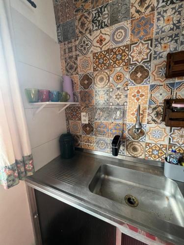 a kitchen with a sink and tiles on the wall at Apê da Lêda Loft - 400m da Praia do Forte in Cabo Frio