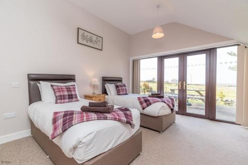 two beds in a room with a window at Bryn-Weirglodd in Llanfihangel-y-pennant