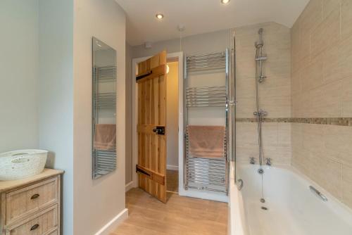a bathroom with a tub and a walk in shower at Bryn-Weirglodd in Llanfihangel-y-pennant