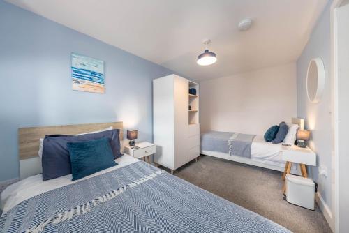 a bedroom with a bed with blue pillows at Bwthyn-Cerrig in Llanerchymedd