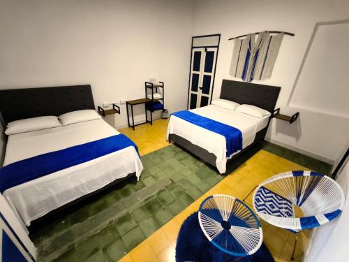 een hotelkamer met 2 bedden en een ventilator bij Hotel Colonial San Roque in San Roque