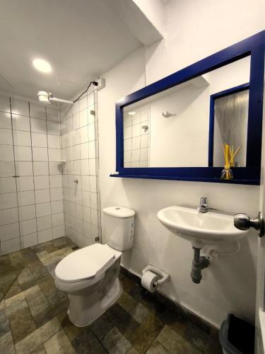 a bathroom with a toilet and a sink and a mirror at Hotel Colonial San Roque in San Roque