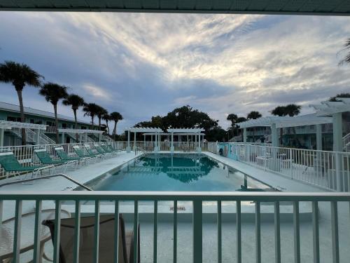 uitzicht op een zwembad vanaf het balkon van een resort bij Magical Mermaid Condo in New Smyrna Beach