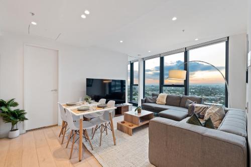 a living room with a couch and a table at Skyline City Views with 75 Inch TV & Pool Gym Sauna in Melbourne