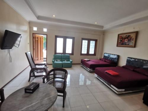 Villa Graha Permata 3 في باتو: غرفة معيشة بها أريكة وسرير وطاولة