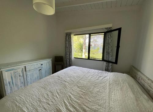 Cómoda casa con amplio jardín في بونتا دل إستي: غرفة نوم بها سرير ونافذة