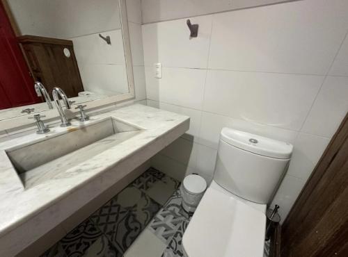 Cómoda casa con amplio jardín في بونتا دل إستي: حمام أبيض مع حوض ومرحاض