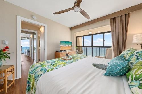 a bedroom with a bed with a view of the ocean at Hololani A204 in Kahana
