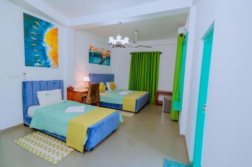 a room with two beds and a table and a dining room at Istana Villa Mirissa in Mirissa