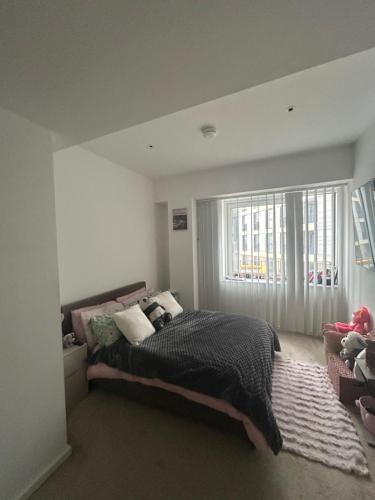 イルフォードにあるSpacious ensuite room in front of stationのベッドと大きな窓のある寝室