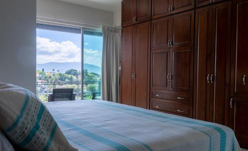 a bedroom with a bed and a large window at Galerias Oaxaca Suites in Oaxaca City