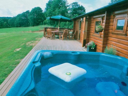 a large blue tub with a seat in it on a deck at Cider Mill Lodge - Hw7420 in Tintern