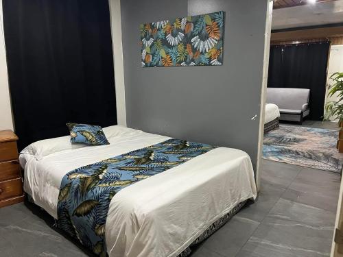 a bed in a bedroom with a picture on the wall at Matasawa Resort - Wailoaloa, Nadi in Nadi
