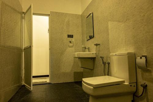 a bathroom with a toilet and a sink at Bailey Beach Villa in Ahangama