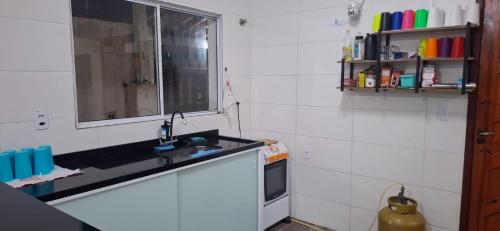 eine Küche mit Spüle und Fenster in der Unterkunft Casa na praia mongagua próximo da plataforma in Mongaguá