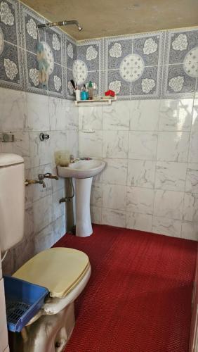 a bathroom with a toilet and a sink at Sky Garden Home in Dhaka