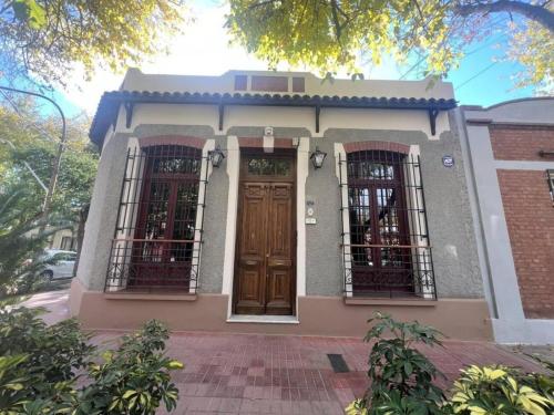 メンドーサにあるTu rincón en ciudadの茶色のドアと窓が2つある小さな家