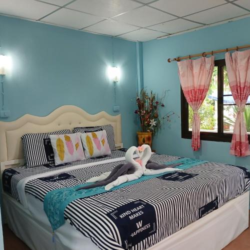 a bedroom with a bed with two swans on it at Thai Garden​ Resort​ Kanchanaburi​ in Kanchanaburi City