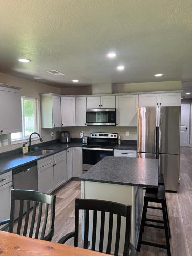 Una cocina con gabinetes blancos y encimera. en Rest and retreat river house, en Grants Pass