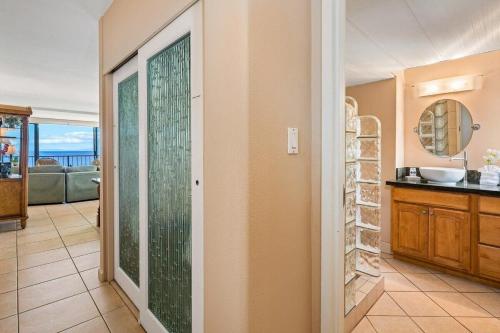 a kitchen with a sliding glass door with a view of the ocean at Maui Kai 808 · MK 808 OceanFront 1BD Kaanapali Beach Ocean Views in Lahaina