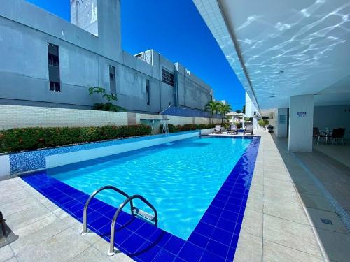 a large blue swimming pool in a building at Imperial Flat in João Pessoa