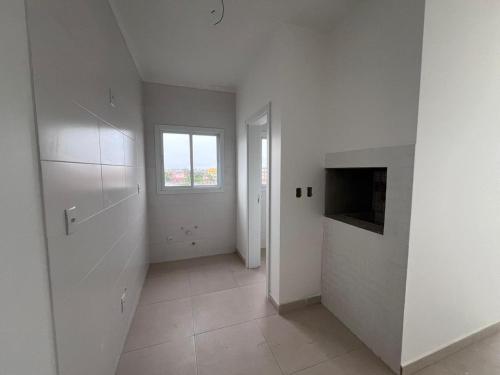 a white room with a window and a door at Residencial Palazzo in Tramandaí