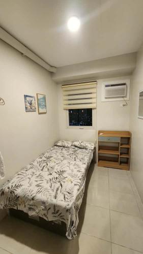 a small bedroom with a bed and a window at 2 Bedroom Condo UDH by ZX Homes Banilad in Mandaue City