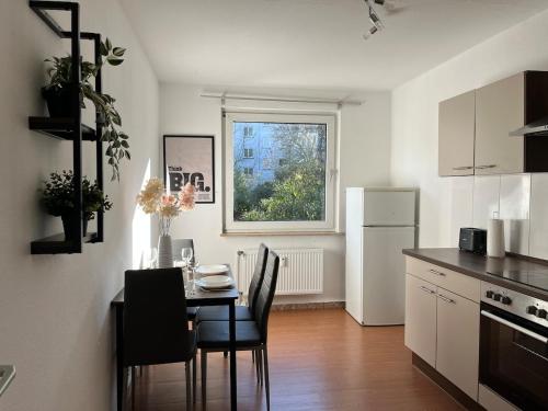 a kitchen with a table with chairs and a window at Gemütliche, zentrale Wohnung nahe Uni & Düsseldorf in Niederdorla